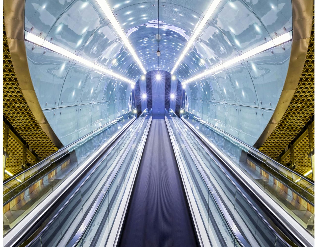 A set of escalators enclosed in a tunnel